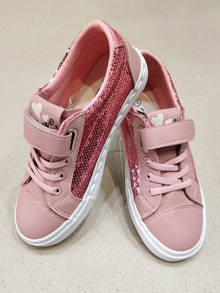 Pair of pink children's sneakers with white soles on a beige background
