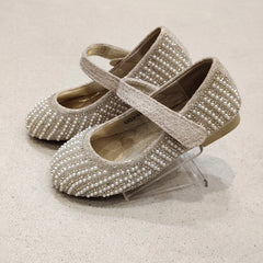 Pair of pearl-studded shoes on a light background