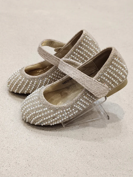 Pair of pearl-studded shoes on a light background