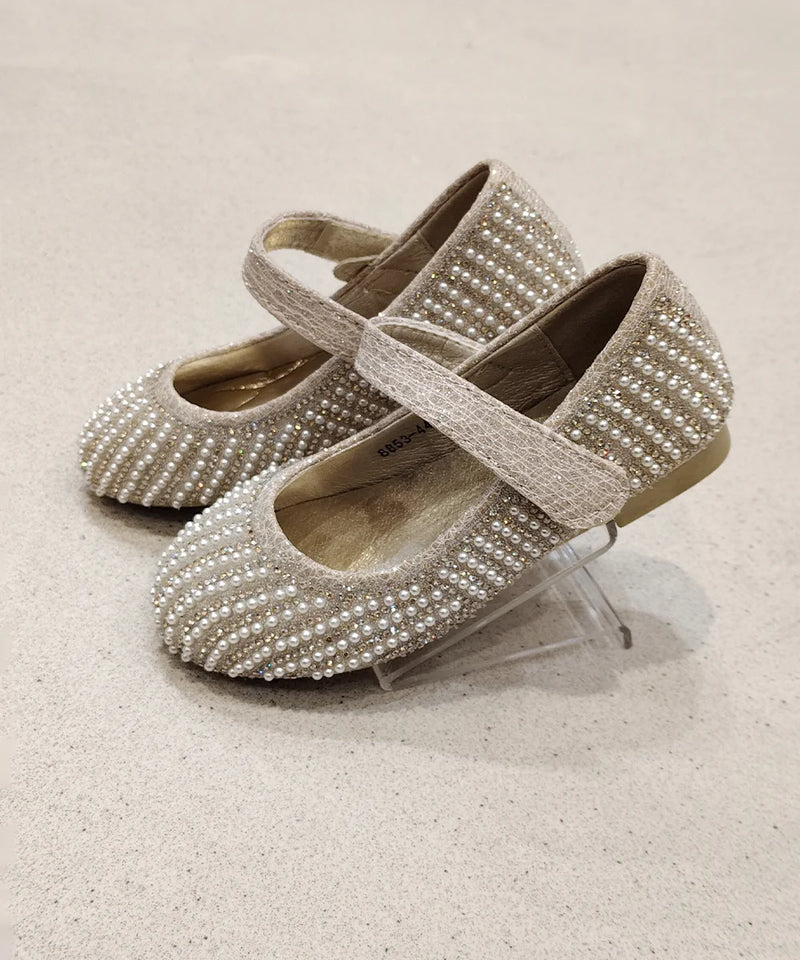 Pair of pearl-studded shoes on a light background