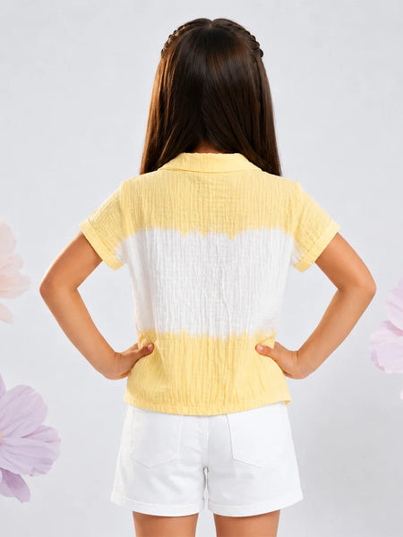 A young girl viewed from behind wearing a yellow and white horizontally striped crinkle-textured short-sleeve top and white shorts, standing against a light gray background with decorative flower graphics.
