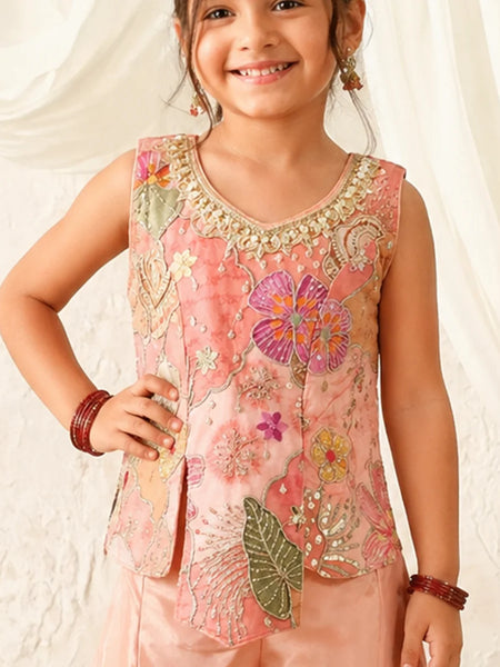 Child wearing a pink embroidered top with floral patterns on a white background