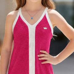 A close-up of a girl wearing a bright pink ribbed knit tank top with white trim and a small white crown logo on the chest, photographed outdoors against a blurred background.