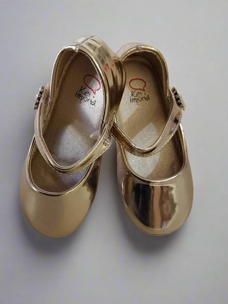 Close-up of girls' metallic gold dress shoes with embellished strap, perfect for festive occasions in Jaipur