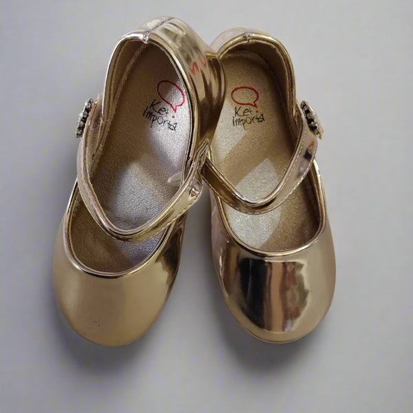 Close-up of girls' metallic gold dress shoes with embellished strap, perfect for festive occasions in Jaipur