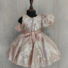 Sparkly dress on a mannequin against a wooden panel background