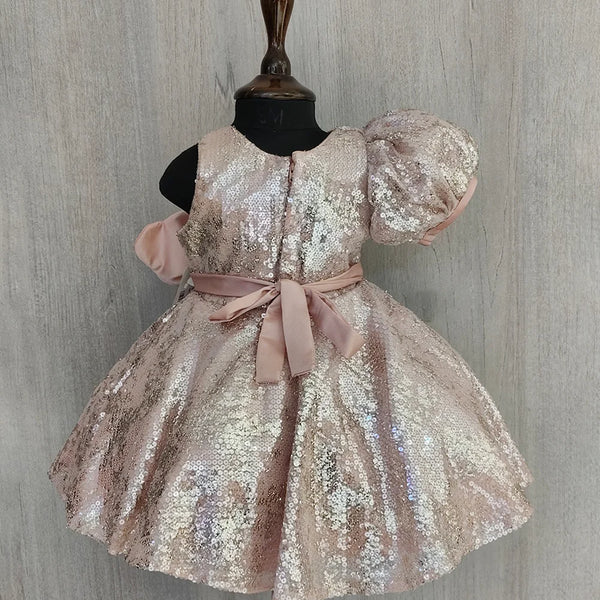 Sparkly dress on a mannequin against a wooden panel background