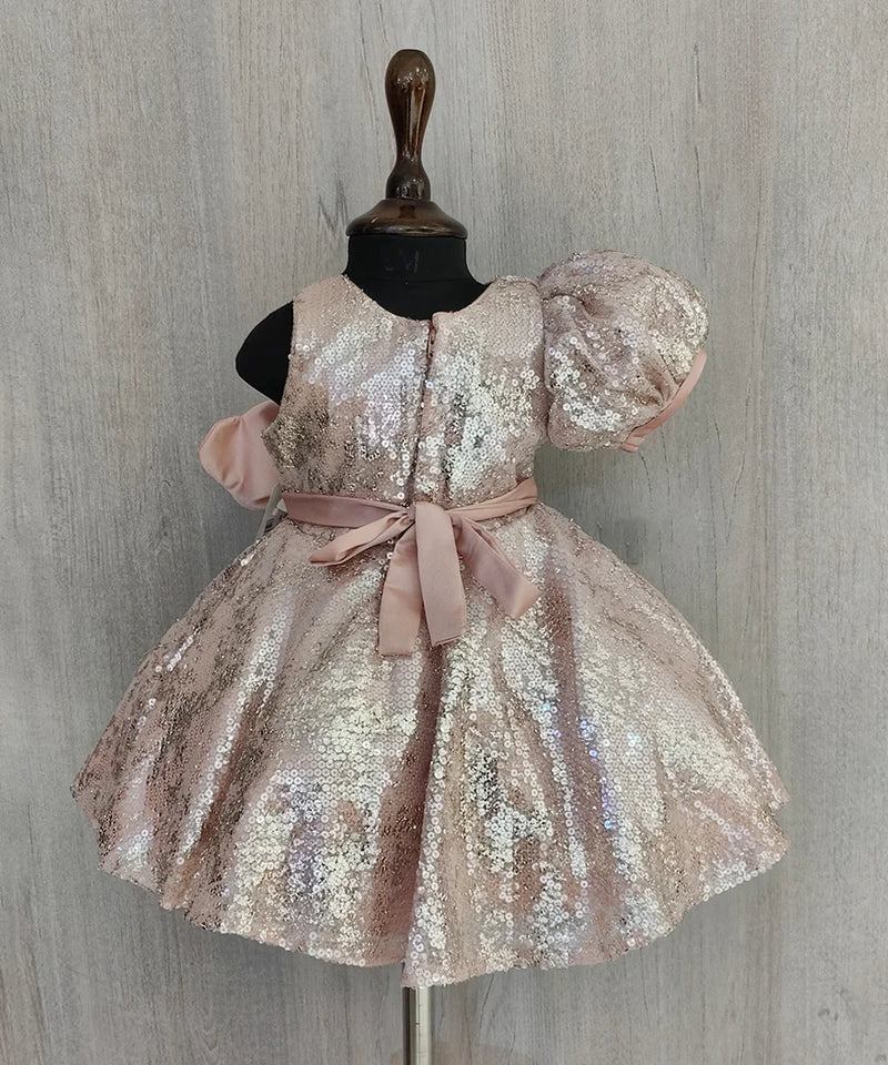 Sparkly dress on a mannequin against a wooden panel background