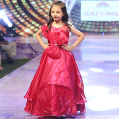 Young girl in a red gown on a stage with a colorful background