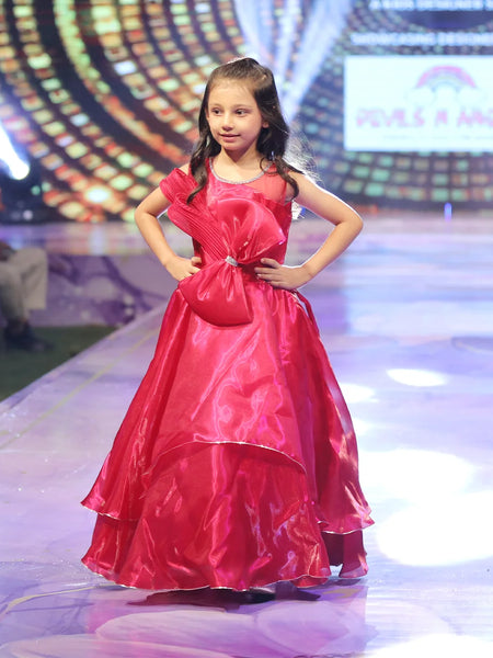 Young girl in a red gown on a stage with a colorful background
