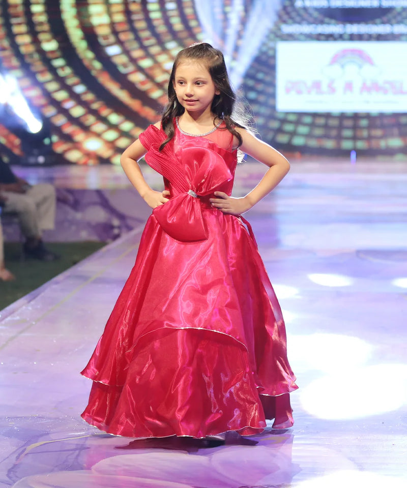 Young girl in a red gown on a stage with a colorful background