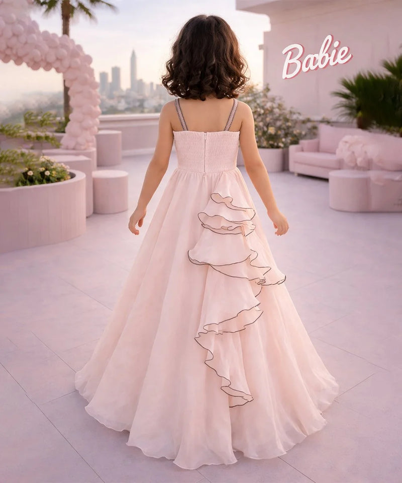 Woman in a pink dress standing on a rooftop with a cityscape and 'Barbie' sign in the background.
