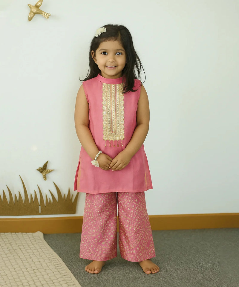 Young girl wearing a pink traditional outfit with a white background