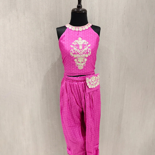 Pink traditional outfit with floral embroidery on a mannequin against a neutral background