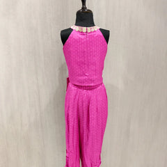 Mannequin wearing a bright pink outfit with a matching top and pants on a neutral background