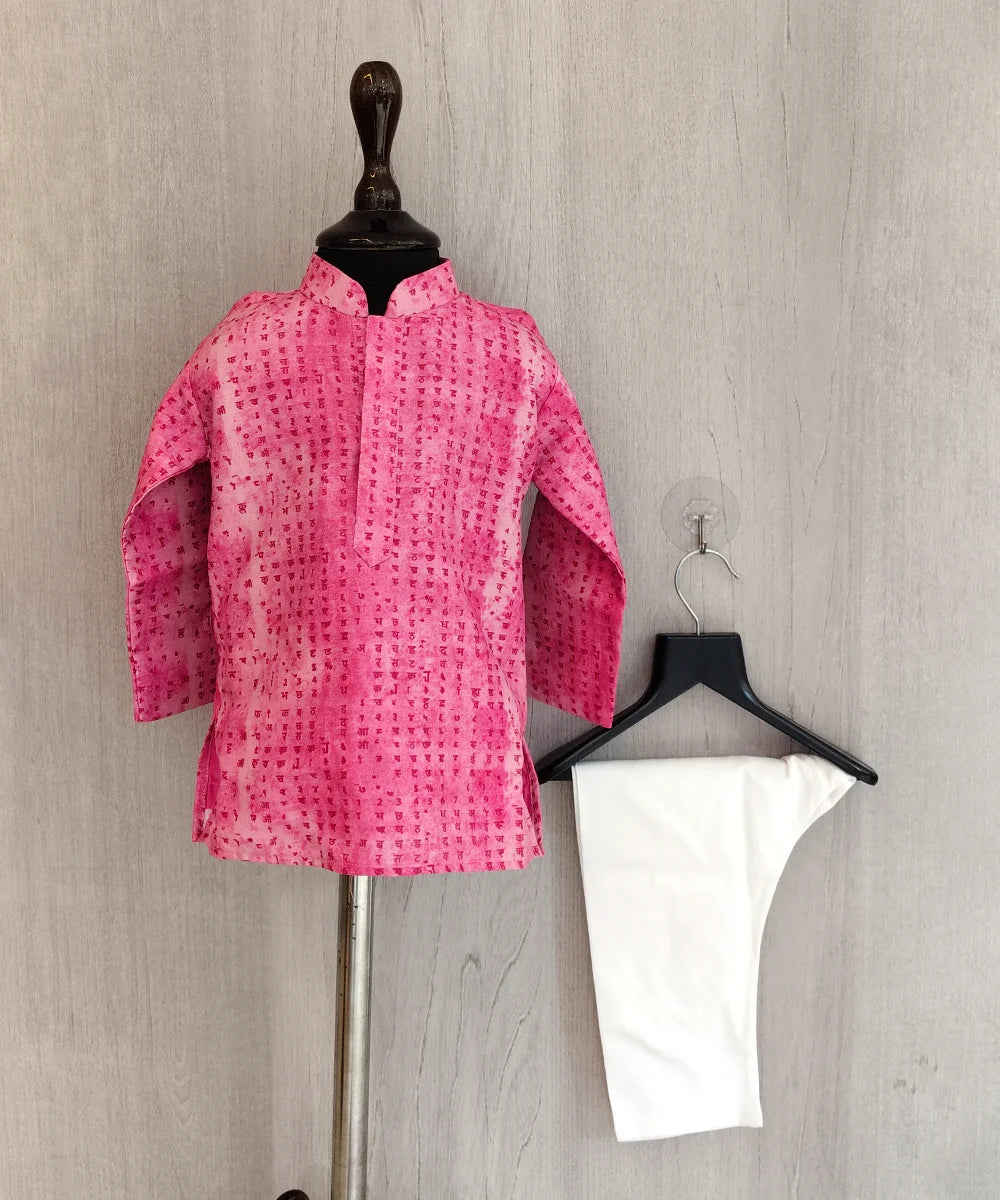 Pink patterned shirt on a mannequin and white pants on a hanger against a gray background