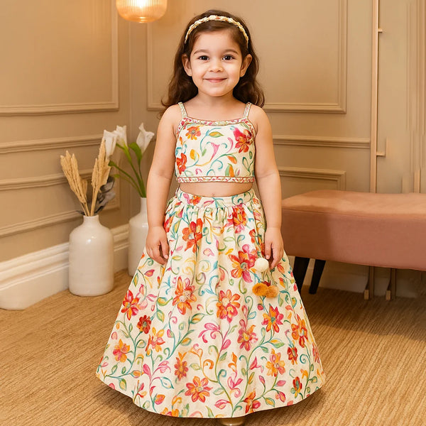 Young girl in a floral dress standing in a room with beige walls and a vase with flowers.