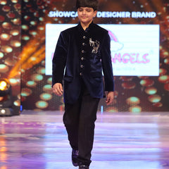 Child model walking on a ramp wearing a blue jodhpuri velvet suit