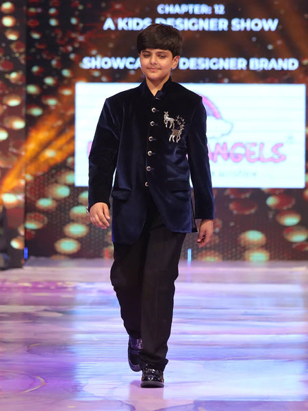 Child model walking on a ramp wearing a blue jodhpuri velvet suit