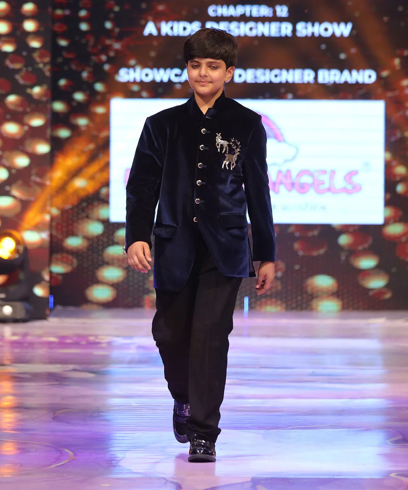Child model walking on a ramp wearing a blue jodhpuri velvet suit