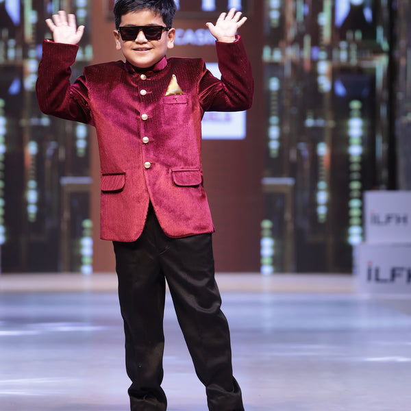 This Maroon party dress for boys consists of a Jodhpuri coat and matching black pants. It features a cute broach and golden-colored pocket square that adds grace to the look.