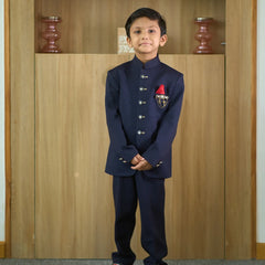 It is a beautiful navy blue coloured Jodhpuri suit for boys. It consists of a Jodhpuri Coat along with matching pants. It features a red coloured pocket square and a nice broach.