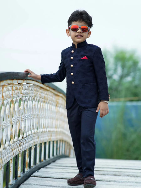 It's a navy blue Colored self-Jacquard design Jodhpuri Suit for Boys. It consists of a Jodhpuri Coat along with matching pants and a red coloured pocket square.