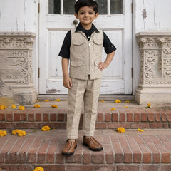 Young boy in a formal outfit standing on steps with decorative elements.