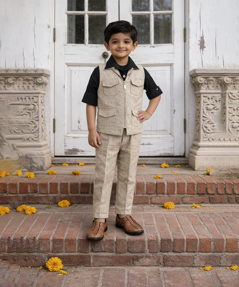 Young boy in a formal outfit standing on steps with decorative elements.