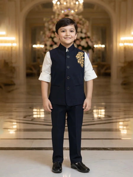 Young boy in formal attire standing in an elegant interior setting with chandeliers.