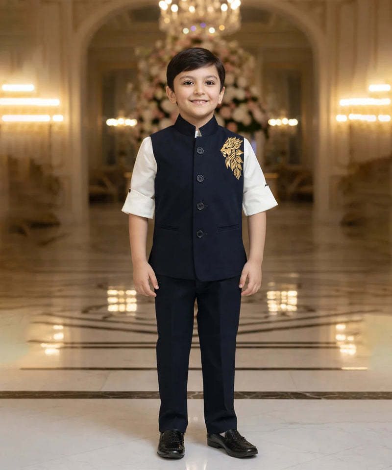 Young boy in formal attire standing in an elegant interior setting with chandeliers.