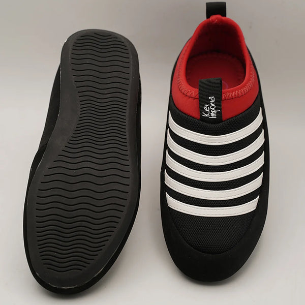 Close-up of kids' black and white striped sports sneakers with red detail, Jaipur.
