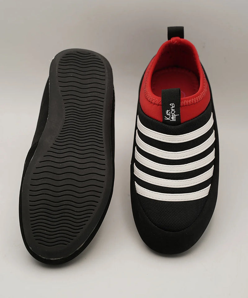 Close-up of kids' black and white striped sports sneakers with red detail, Jaipur.
