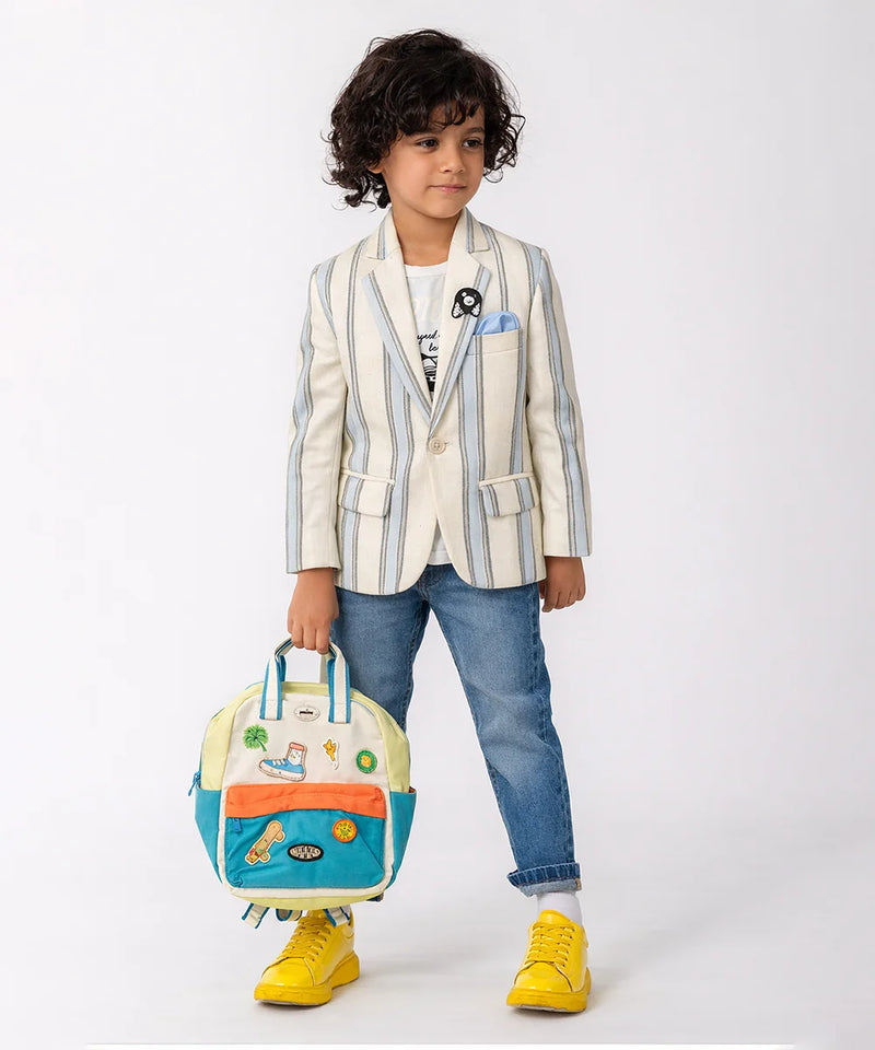 Child wearing a striped blazer with a colorful backpack on a white background