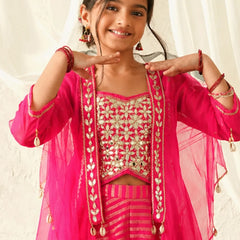 Young girl in a pink traditional outfit with gold embroidery against a white curtain background