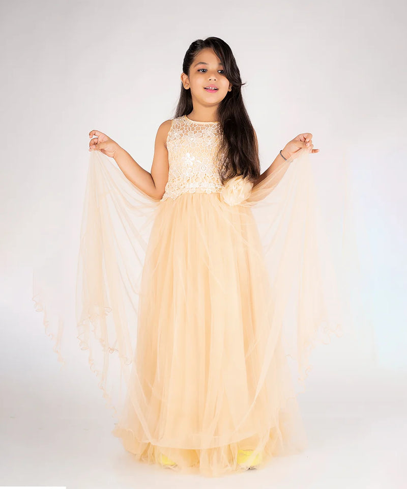 Young girl in a beige evening gown with lace details on a white background