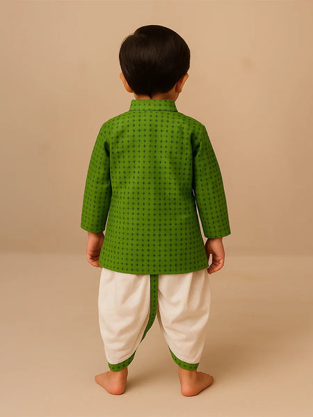 Child wearing a green traditional outfit with white dhoti on a beige background
