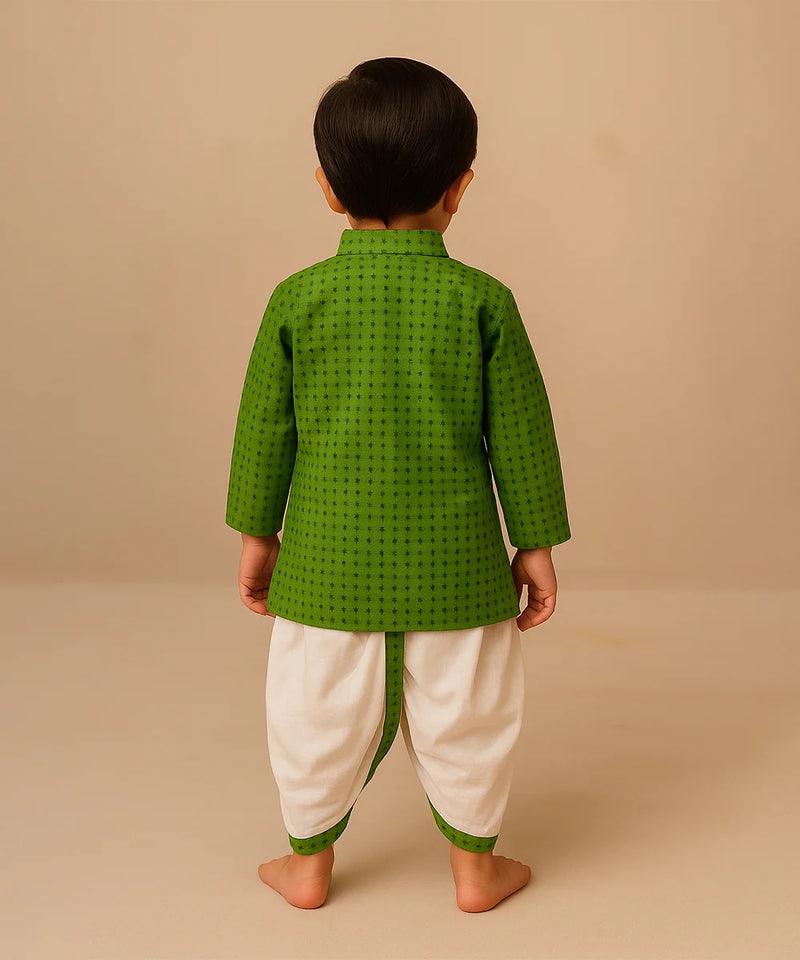 Child wearing a green traditional outfit with white dhoti on a beige background