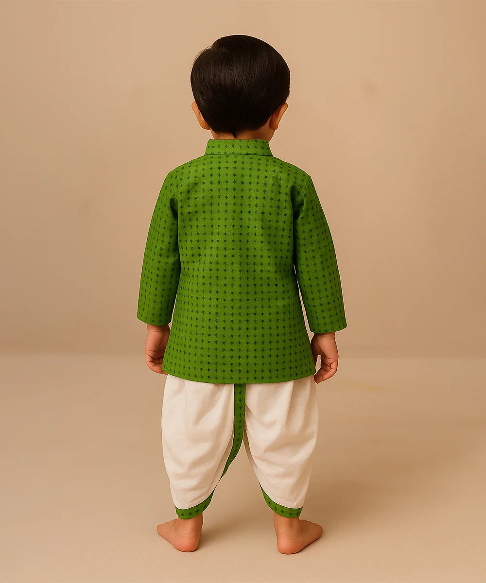 Child wearing a green traditional outfit with white dhoti on a beige background