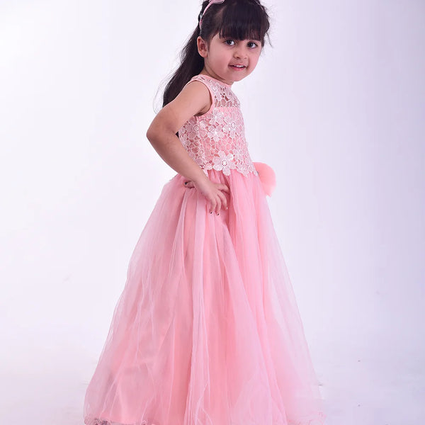 Young girl in a pink dress with lace details on a white background