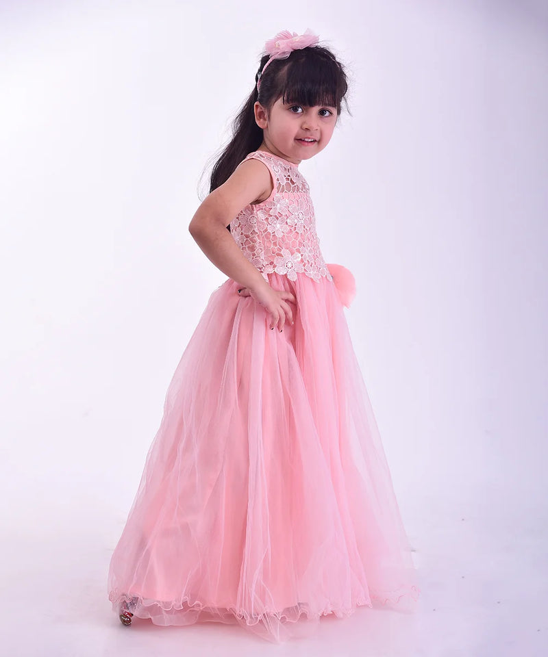 Young girl in a pink dress with lace details on a white background