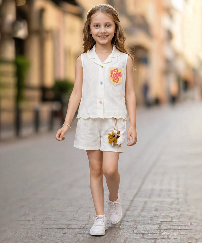 Young girl in a white outfit with floral details walking on a street.