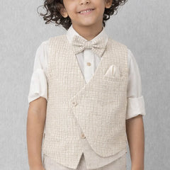 Young boy wearing a beige vest and bow tie against a gray background