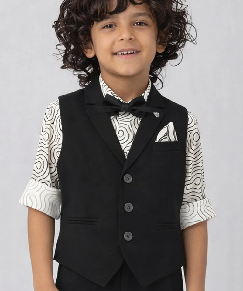 Child wearing a black vest over a patterned shirt on a plain background