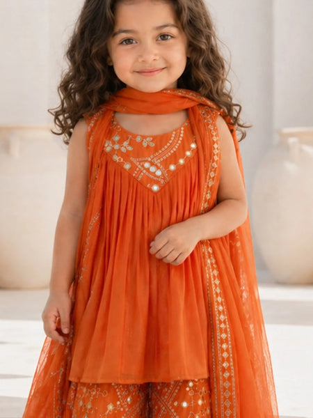 Young girl wearing an orange embroidered traditional outfit with a neutral background