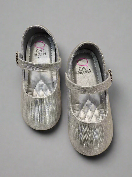 Close-up of shimmering silver party flats for girls with secure strap and jeweled flower, Jaipur


