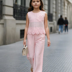 Young girl in a pink outfit walking on a city street.