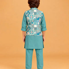A child model shown from the back wearing a teal-green kurta set with a patterned patchwork vest. The vest features a mix of blue, white, and green geometric and floral motifs.