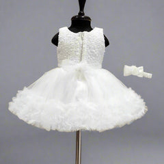 White flower girl dress on a mannequin with a wooden background