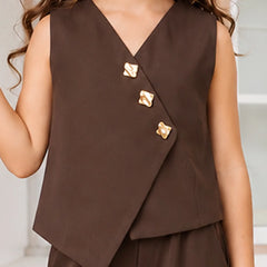 A child wearing a sleeveless brown wrap-style vest with three decorative gold-tone buttons and matching brown bottoms, shown against a softly blurred indoor background.
